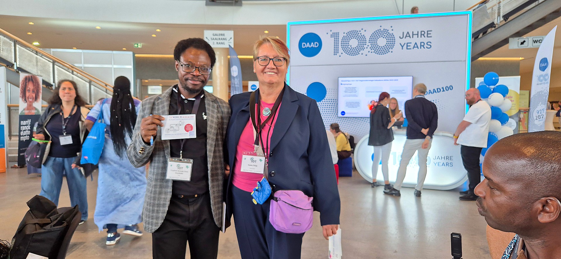 Hayford Anyidoho mit einer Ausstellerin am Stand zum 100-jährigen Jubiläum des DAAD